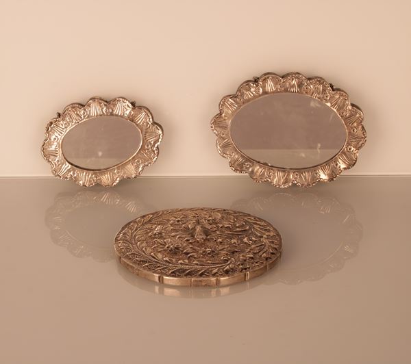 Lotto di tre specchi "a fiore" in argento 800/1000 con catenella, due ovali ed uno tondo