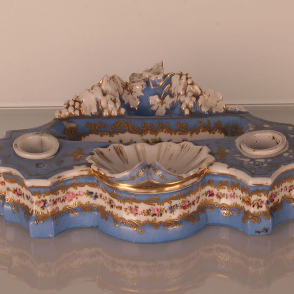 Servito da scrittoio in porcellana policroma sui tono dell'azzurro con decoro in oro al piano mistilineo e fascia di roselline ai fianchi. Porta inchiostro bianchi asportabili.  - Asta Aperti per ferie:  l'asta di agosto. In occasione della 729esima Perdonanza Celestiniana - Gliubich Casa d'Aste