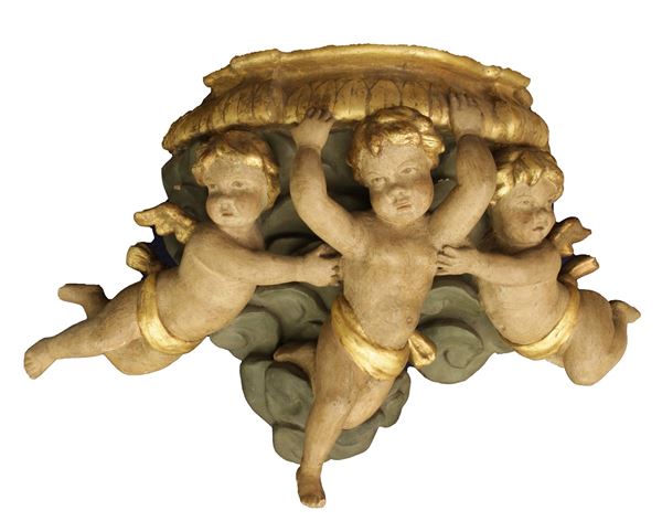 Mensola in legno intagliata, dipinta e dorata con tre putti