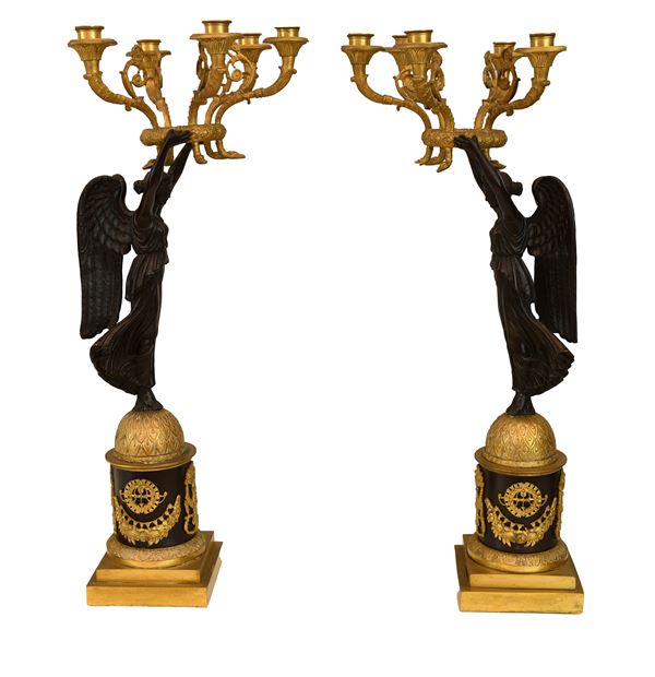 Coppia di straordinari flambeaux di gusto classico in bronzo dorato e patinato. Manifattura francese degli inizi del XIX secolo
