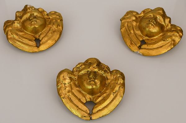 Lotto di tre cherubini in legno intagliato e dorato
