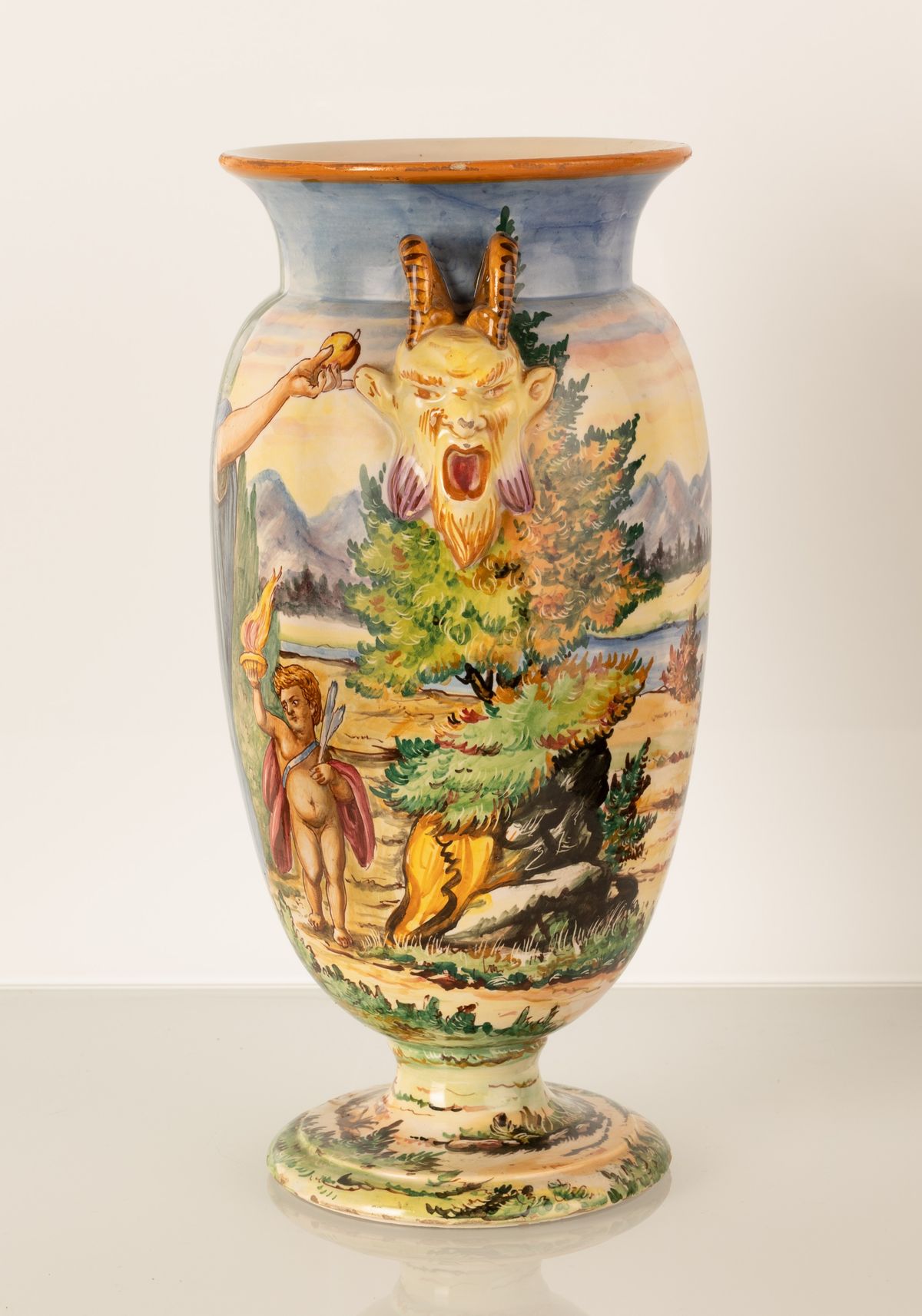 Vaso in maiolica a forma di urna con anse a rilievo imitanti due teste di fauni urlanti. Manifatt...