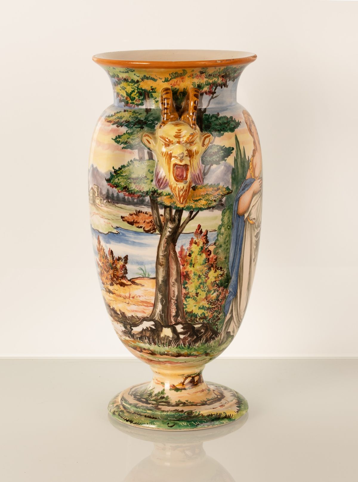 Vaso in maiolica a forma di urna con anse a rilievo imitanti due teste di fauni urlanti. Manifatt...