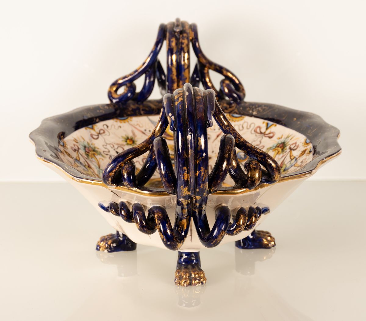 Coppia di centrotavola in maiolica con anse serpentiformi e zampe leonine. Manifattura A. Ciulli,...