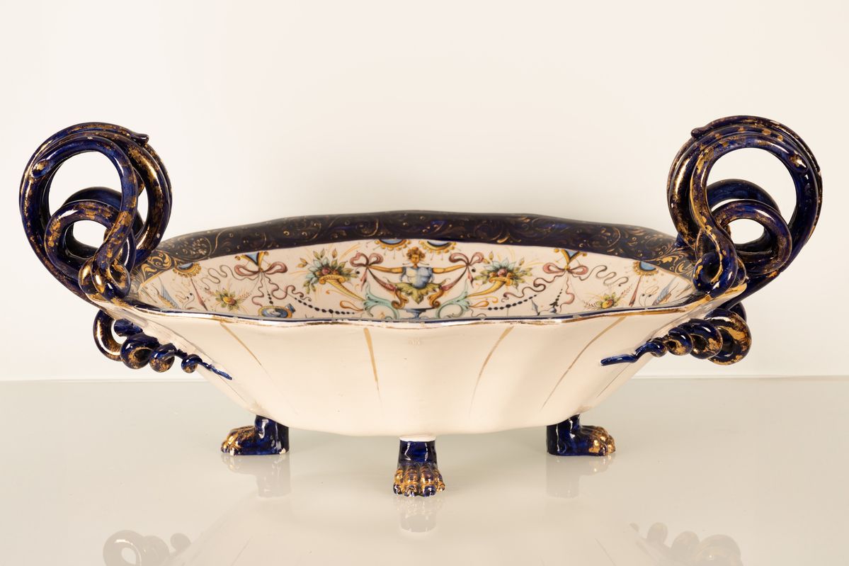 Coppia di centrotavola in maiolica con anse serpentiformi e zampe leonine. Manifattura A. Ciulli,...