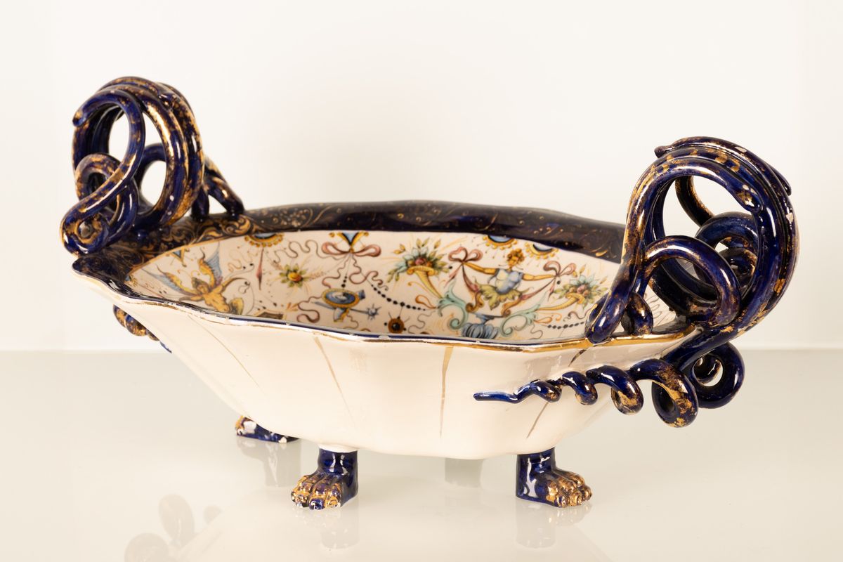 Coppia di centrotavola in maiolica con anse serpentiformi e zampe leonine. Manifattura A. Ciulli,...