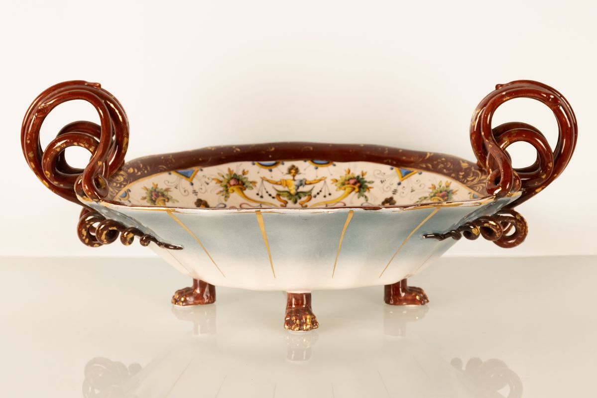 Coppia di centrotavola in maiolica con anse serpentiformi e zampe leonine. Manifattura A. Ciulli,...