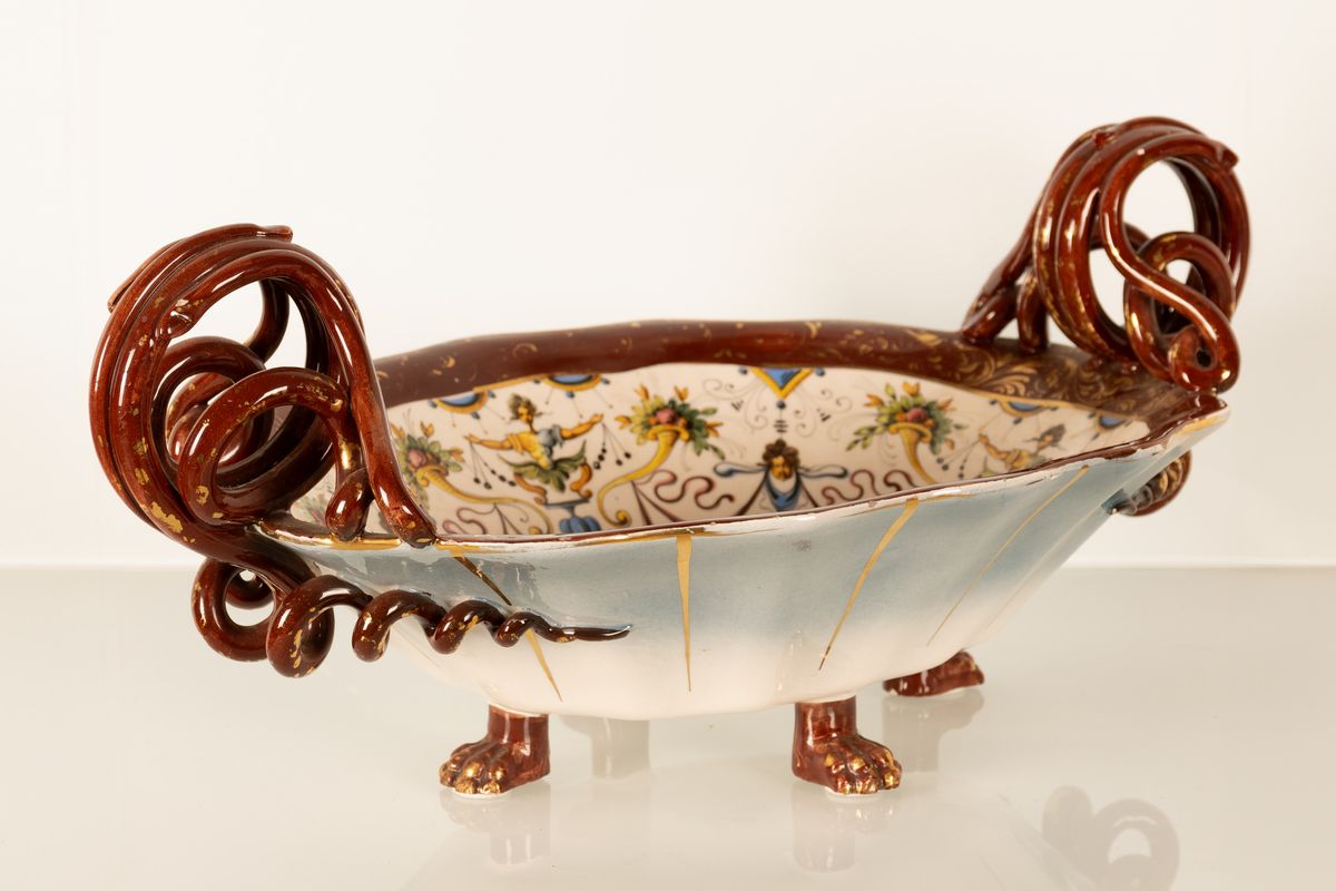 Coppia di centrotavola in maiolica con anse serpentiformi e zampe leonine. Manifattura A. Ciulli,...