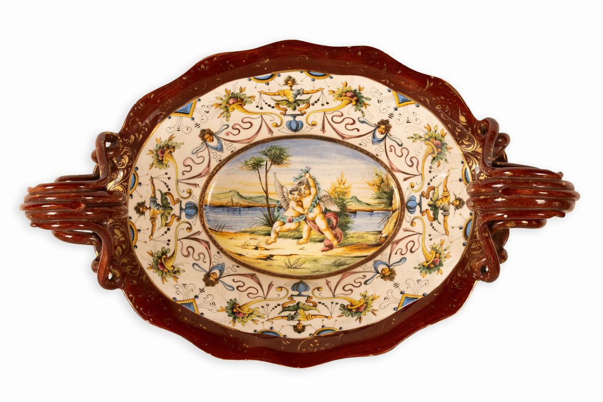 Coppia di centrotavola in maiolica con anse serpentiformi e zampe leonine. Manifattura A. Ciulli,...