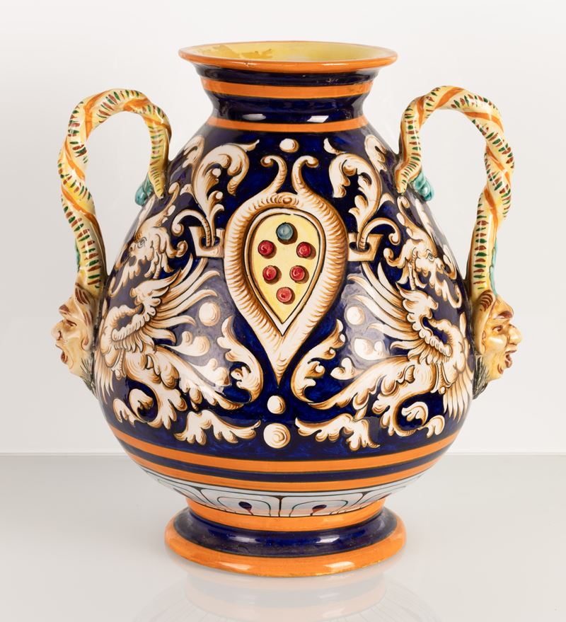 Vaso in maiolica biansato con anse ritorte terminanti a mascheroni antroomorfi. Manifattura Egist...