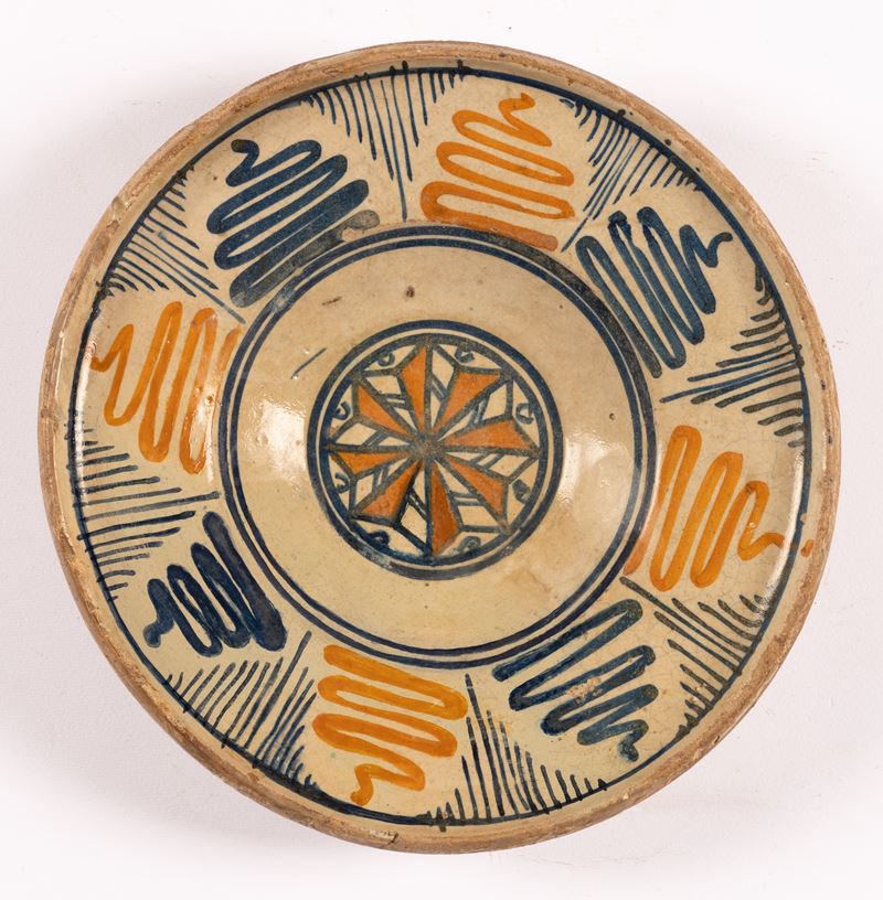 Piatto Decorato alla Tesa con Motivi Geometrici ed Ondulati in Blu e Manganese. al Cavetto Decoro...