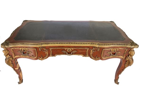 Tavolo Bureau Plat  con applicazioni in bronzo dorato, piano di forma sagomata profilato da bordo in bronzo dorato rivestito in pelle. Manifattura francese dell'ultimo quarto del XIX secolo e gli inizi del XX secolo