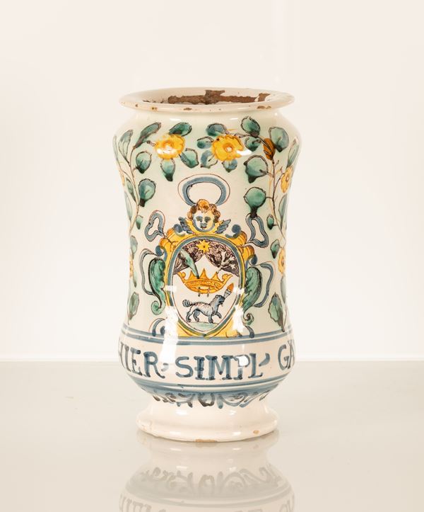 Manifattura di Torre dei Passeri, fine XVII secolo - primi decenni del XVIII secolo. Albarello da farmacia con stemma dell'inquisizione dell'ordine domenicano sormontato da testa di angelo con aureola. Ai lati due serti fioriti stanti ad incorniciare lo stemma. Alla base ed in lettere capitali la dicitura " HIER, SIMPL, GAL"