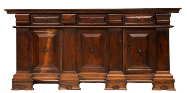 Grande credenza a tre sportelli in noce seicentesca con fronte scandito da tre cassetti bugnati. Mantova, XVII secolo