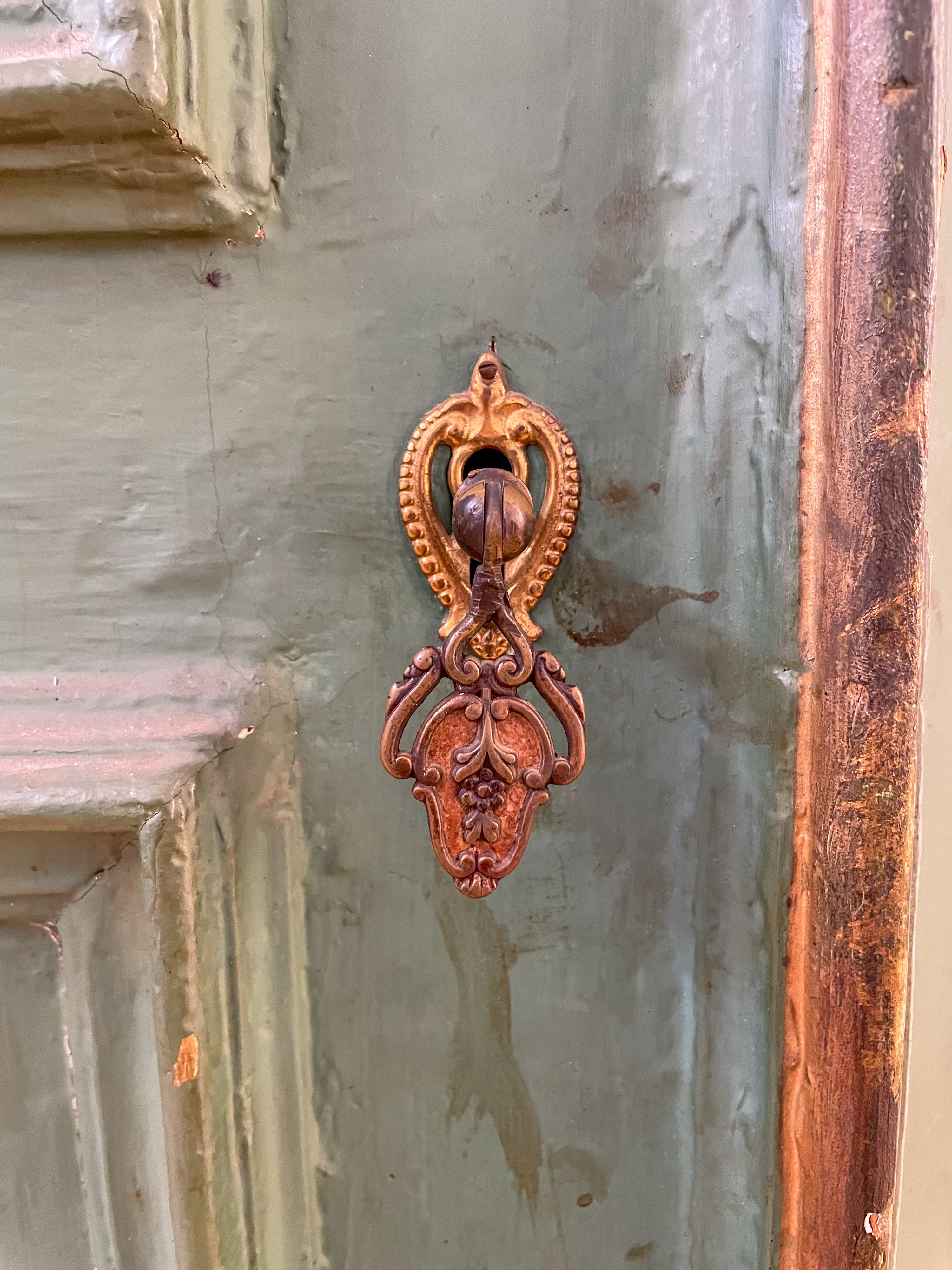 Angoliera ad un'anta in legno di abete laccata e ridipinta nei colori del verde e dell'oro. Centr...