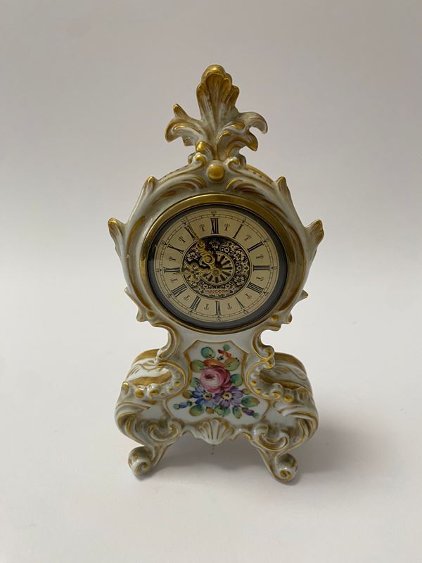 Piccolo orologio da camino in porcellana di Capodimonte con ricche volute e decori floreali