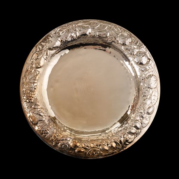 Grande centrotavola tondo in argento 800/000 con decoro di frutta e foglie a rilievo. Punzone 556FI (Cassetti - Firenze)