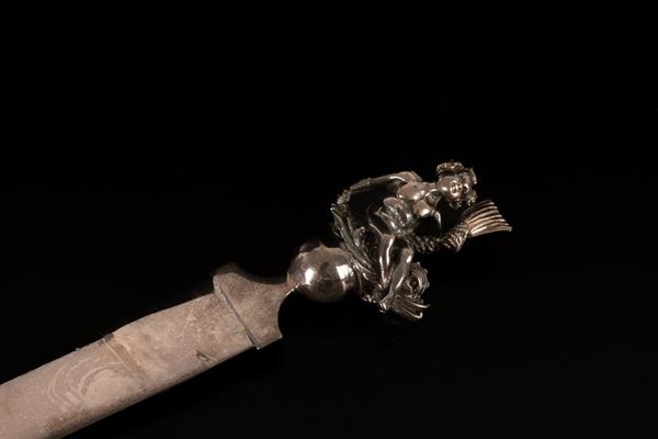Tagliacarte in argento 925/000 con manico decorato con putto assiso su un pesce. Punzone 885FI.