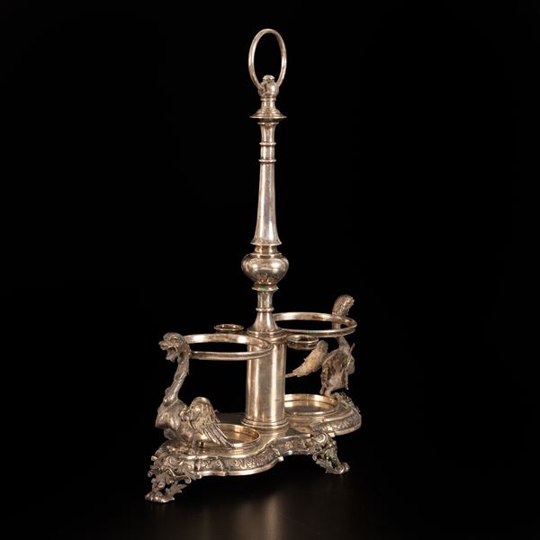 Set olio e aceto senza bottiglie di foggia baroccheggiante, finemente lavorato, con alle due estremità sculture a tutto tondo rappresentanti Arpie.