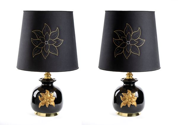Coppia di lampade da tavolo in ceramica Cenacchi, Molinella. Corpo in ceramica nera con fiore oro a ornamento principale decorato a mano. Paravento originale con marchio e fiore dorato. Struttura in metallo dorato