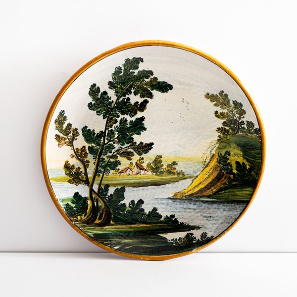 Manifattura di Castelli della met&#224; del XX secolo - Piatto in maiolica decorato con paesaggio fluviale