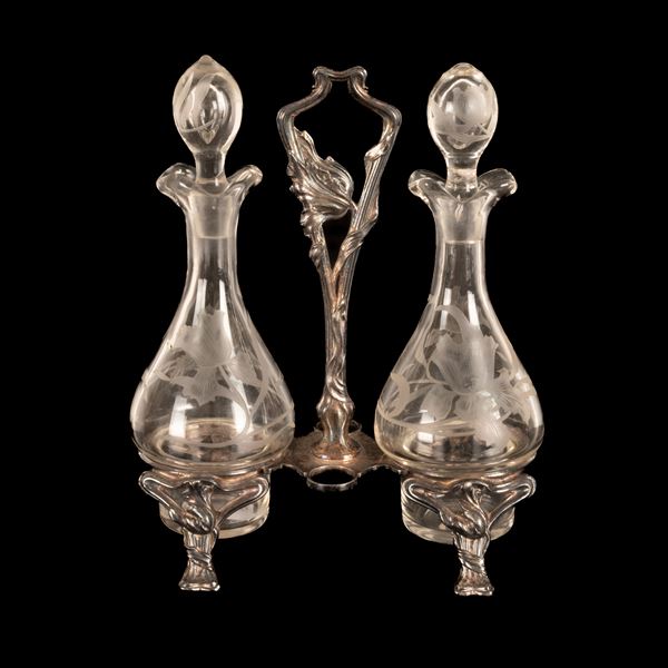 Set olio e aceto Art Nouveau in metallo in bagno d'argento e vetro. Francia, prima decade del Novecento.