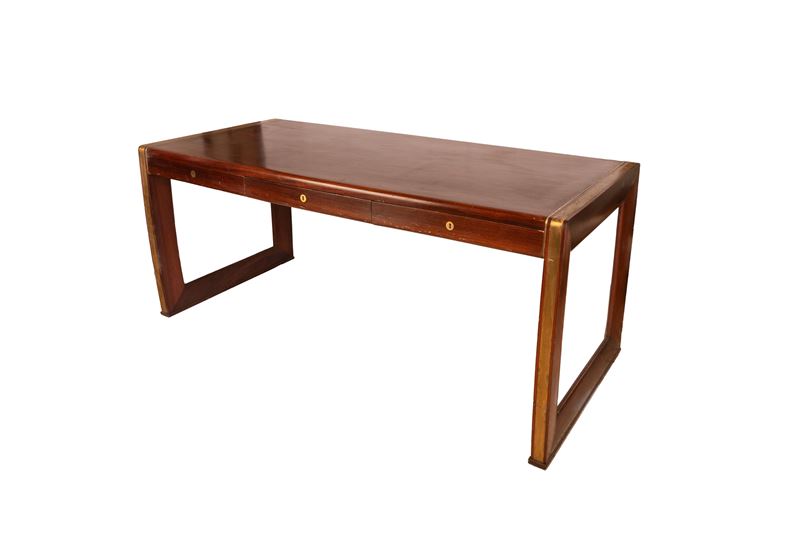 Grande scrivania con tre cassetti a scomparsa sul fronte ed eleganti filettature ottonate che cor...