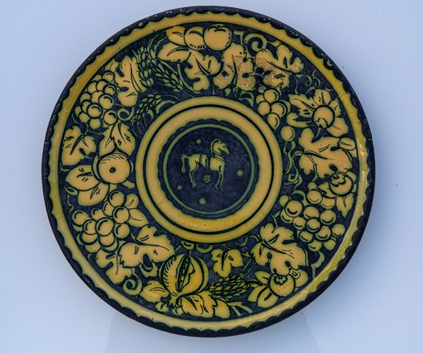 Manifattura ascolana degli anni Venti del XX secolo - Piatto maiolica ascolana con decoro e frutti sulla tesa e cavallo nel tondo centrale 