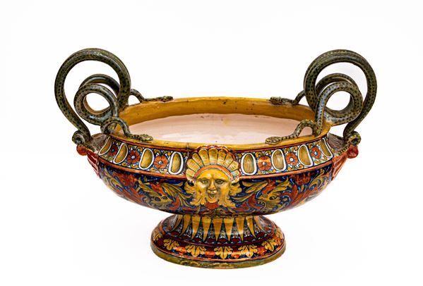 Manifattura di Gualdo Tadino del XX secolo - Vaso centrotavola in maiolica a lustro metalico biansato con manici a serpenti e mascherone e rilievo. Decoro a raffaellesche di gusto neorinascimentale. S.M.C (Società Mastro Giorgio), 1925