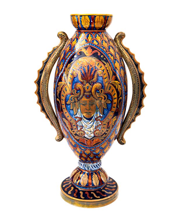 Manifattura di Gualdo Tadino degli inizi del XX secolo - Vaso ovale in maiolica decorata a lustro metallico di gusto eclettico con decoro a mascherone sul fronte ed anse di gusto moresco. Al retro tre etichette di antiche collezioni