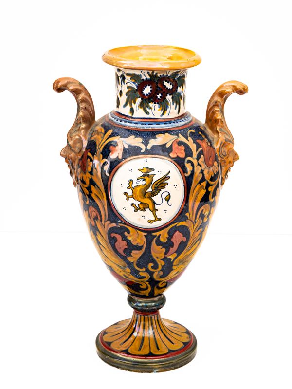 Manifattura di Gualdo Tadino del XX secolo - Anfora biansata in maiolica decorata a lustro metallico con prese a foggia di mascheroni, con decori di mazzi fioriti a collo e grifone rampante in riserva centrale 