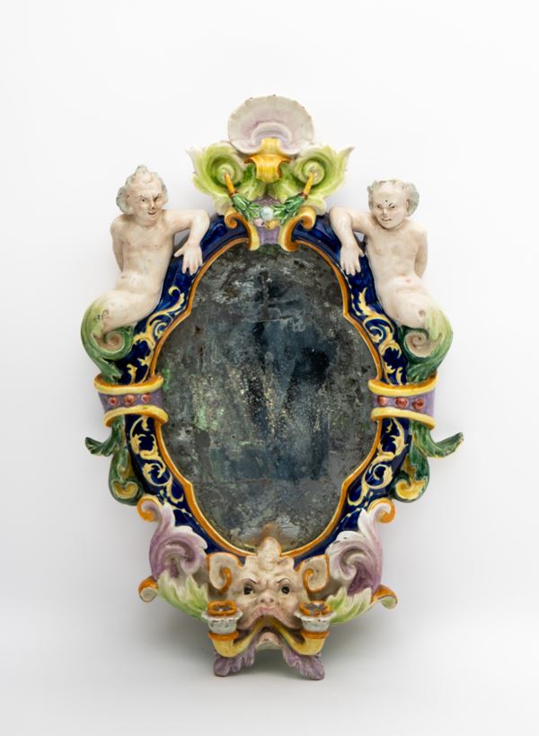 Manifattura Battaglia, Napoli XIX secolo - Deliziosa applique candeliere a due fuochi in maiolica policroma con mascherone, figure grottesche ai lati e specchio al mercurio.