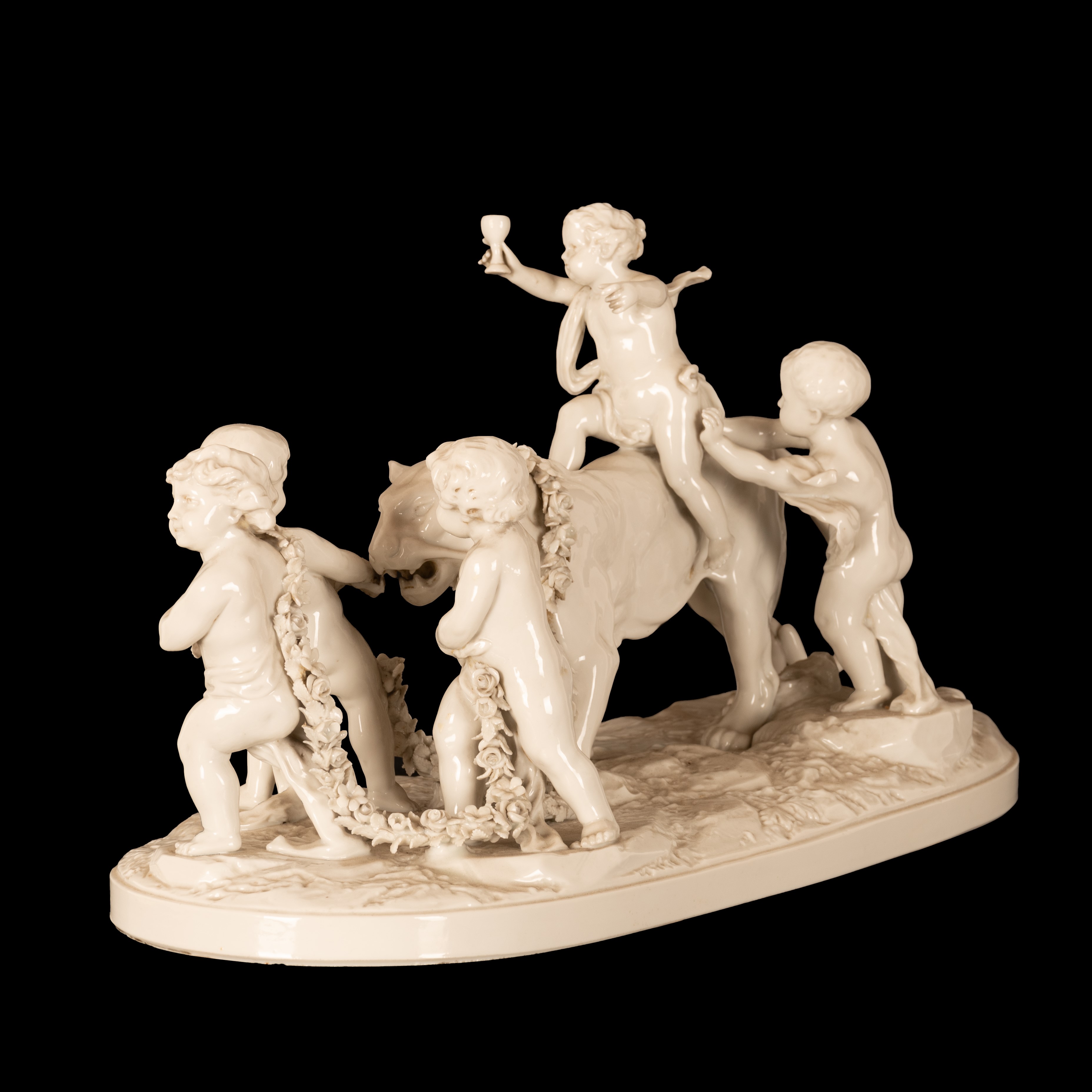 Gruppo in porcellana bianca composto da cinque eroti stanti a condurre una pantera incatenata da ...