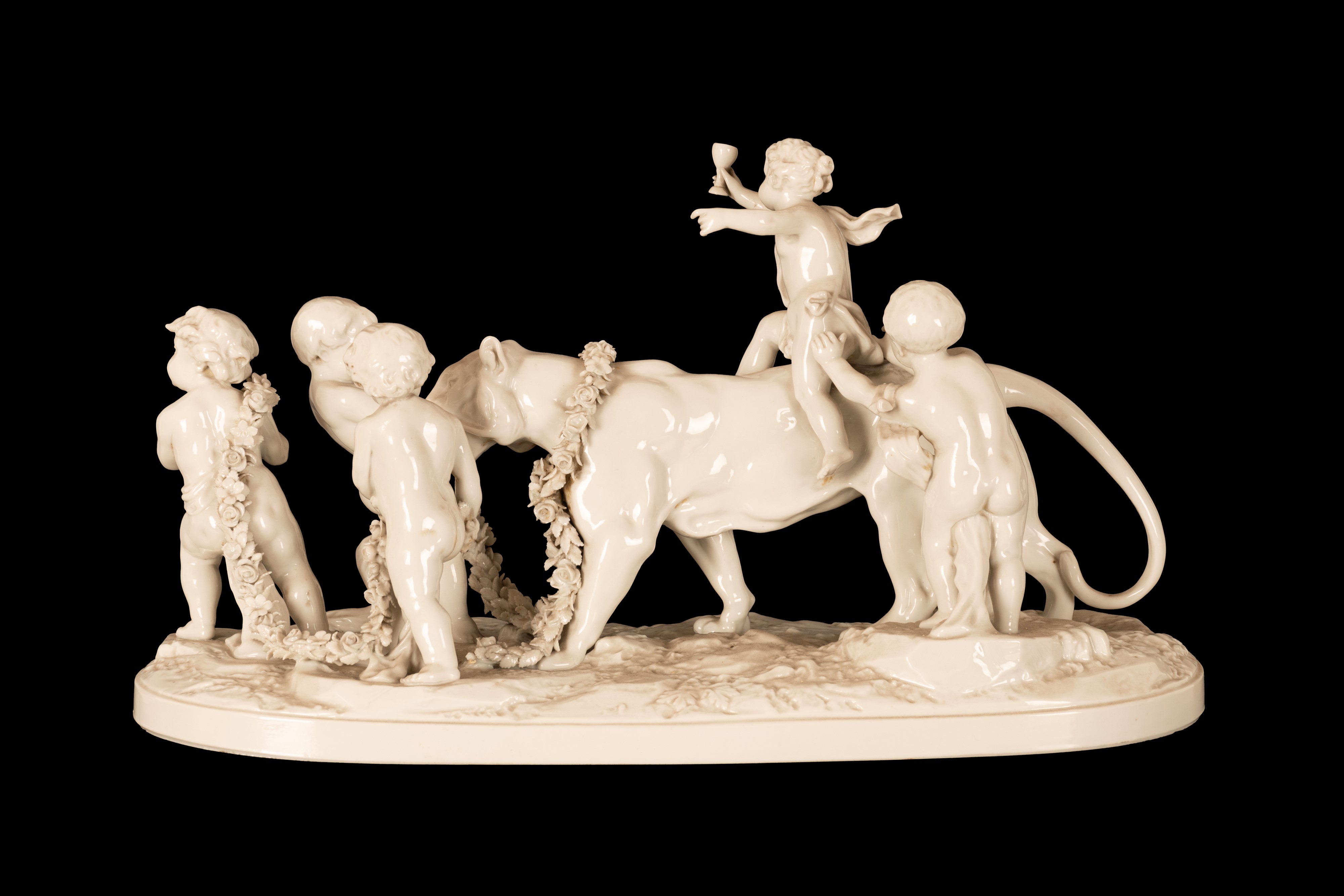 Gruppo in porcellana bianca composto da cinque eroti stanti a condurre una pantera incatenata da ...
