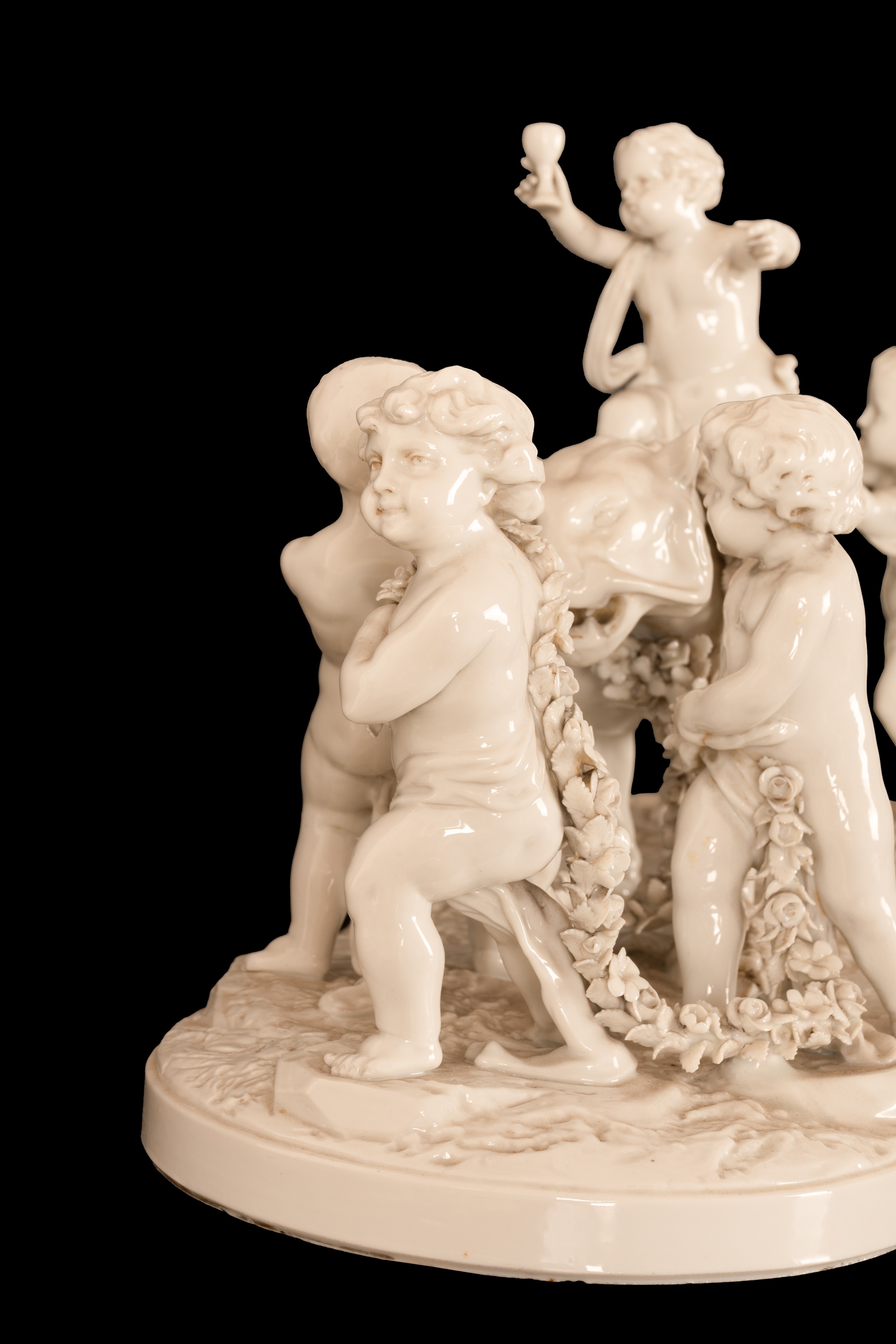 Gruppo in porcellana bianca composto da cinque eroti stanti a condurre una pantera incatenata da ...