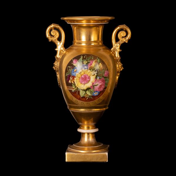 Vaso biansato ovoidale in porcellana con elementi decorativi neoclassici realizzati in oro lucido ed opaco stanti a racchiudere una riserva circolare recante elementi floreali policromi. 