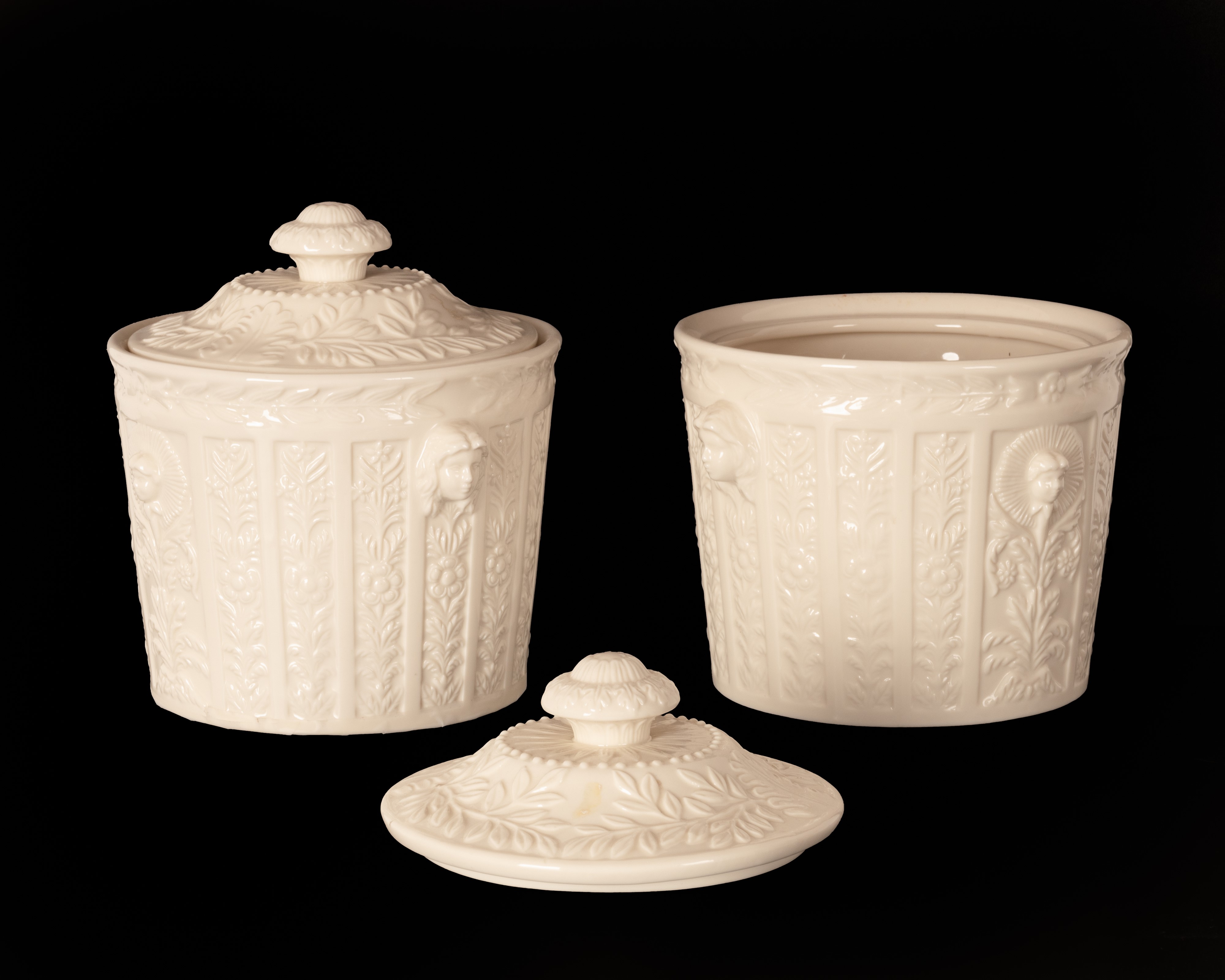 Coppia di cremiere in porcellana bianca con decoro a rilievo di gusto neoclassico.