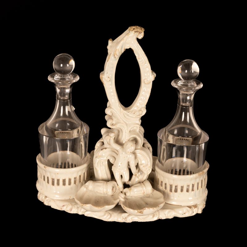 Oliera da tavola in terraglia bianca con decori a rilievo di gusto settecentesco.