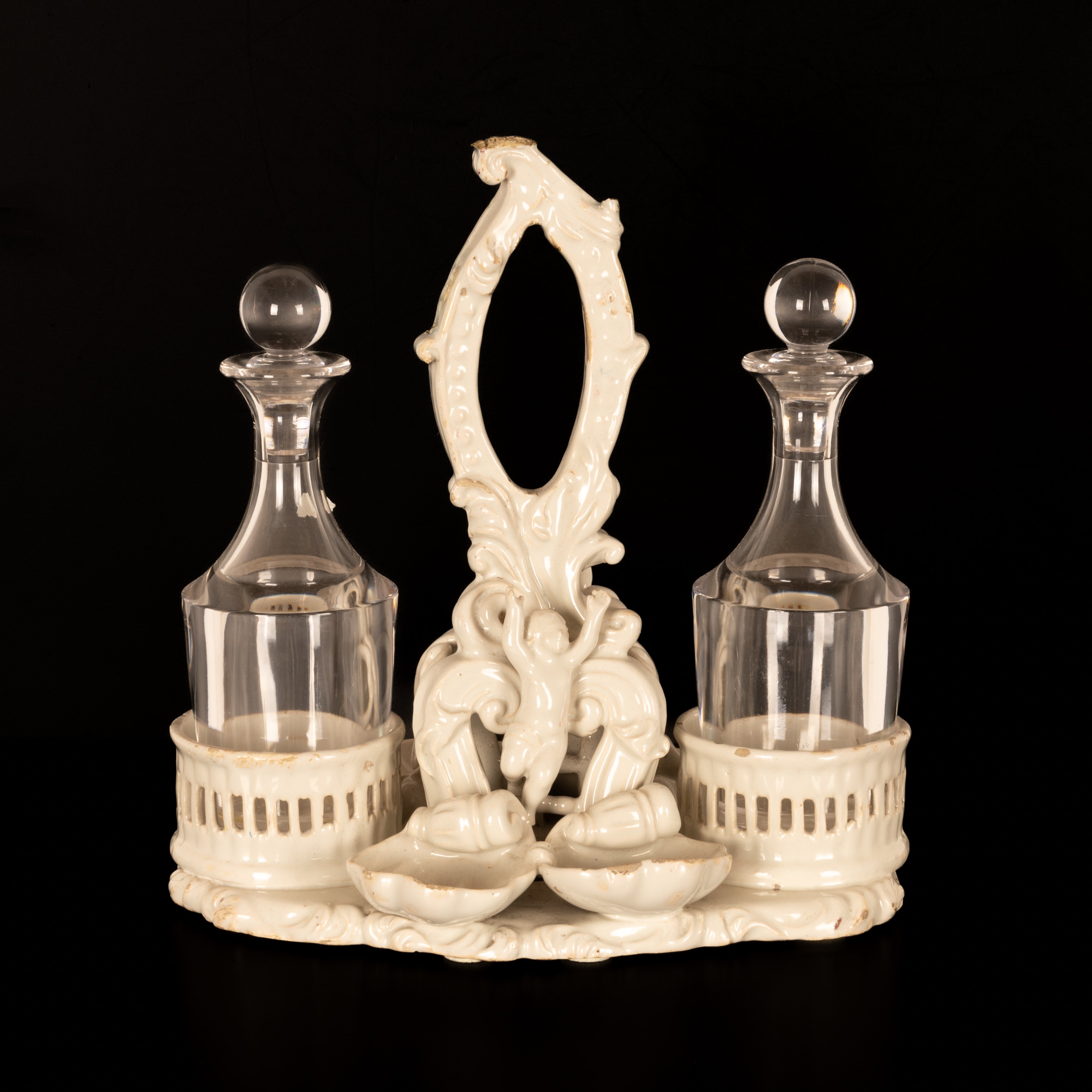 Oliera da tavola in terraglia bianca con decori a rilievo di gusto settecentesco.