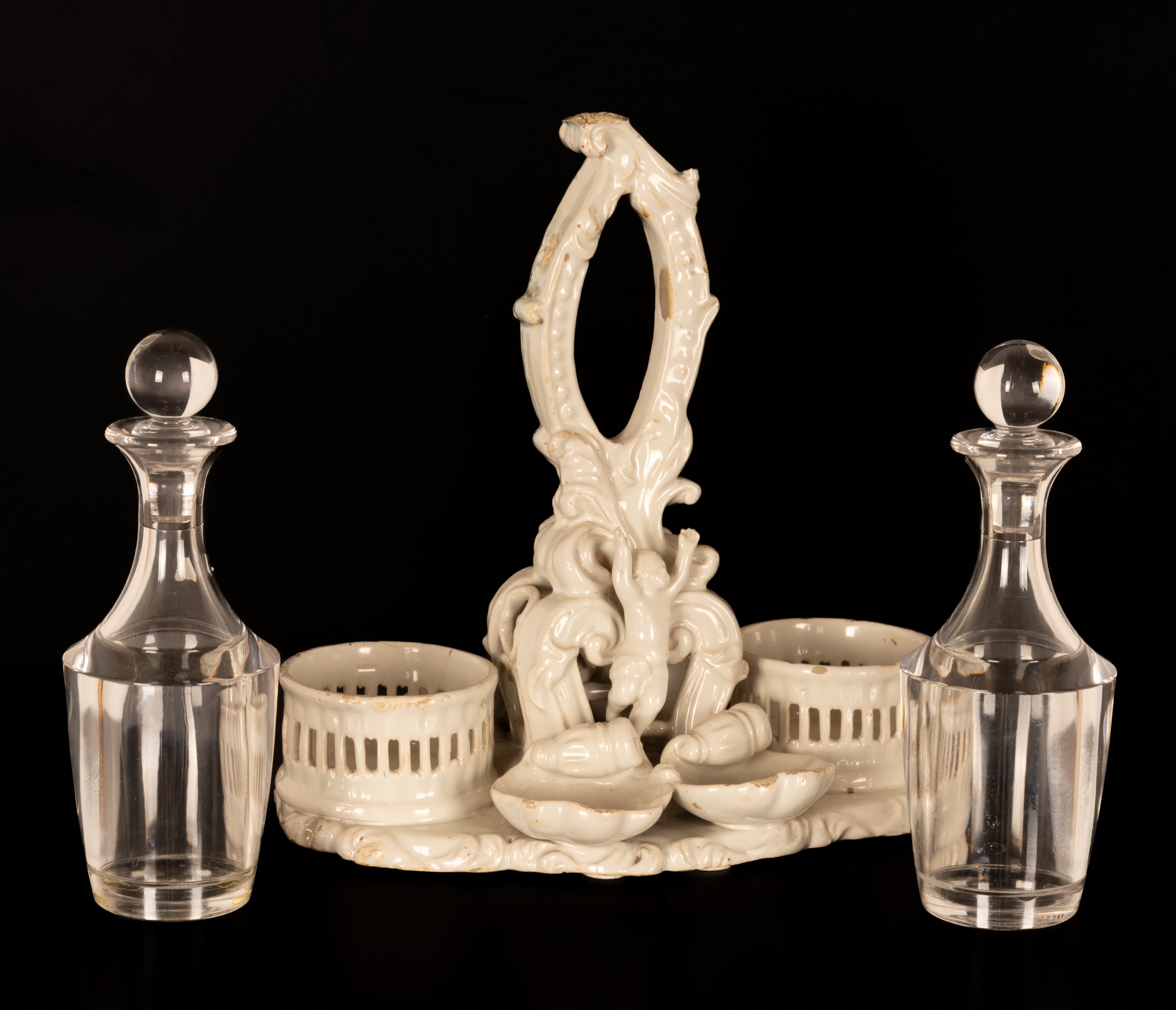 Oliera da tavola in terraglia bianca con decori a rilievo di gusto settecentesco.